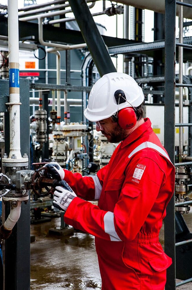 Profissional com vestuário de emergência em ambiente industrial